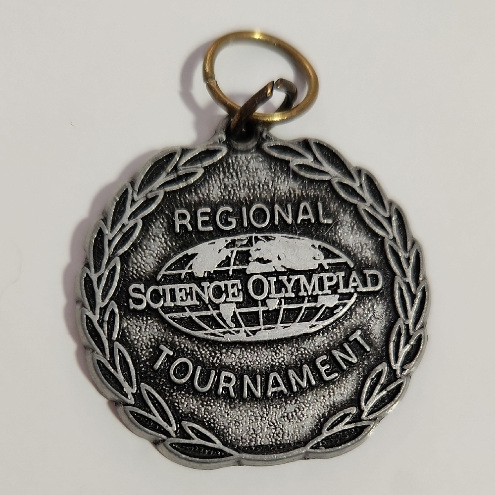 Ornate Silver Medallion with Intricate Scrollwork and Raised Lettering